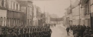 Preview: altes Foto - Truppe Soldaten marschieren durch die Strasse - Ort ? Banner Wir grüßen unseren Führer
